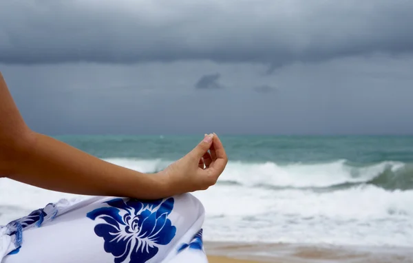 Vista de una joven agradable practicando yoga en la playa tormentosa — Foto de Stock
