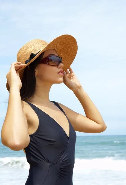 Vista de mulher agradável em roupa preta natação segurando seu chapéu de palha — Fotografia de Stock