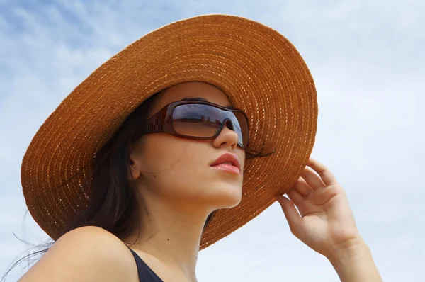 Vue de belle femme en maillot de bain noir tenant son chapeau de paille — Photo