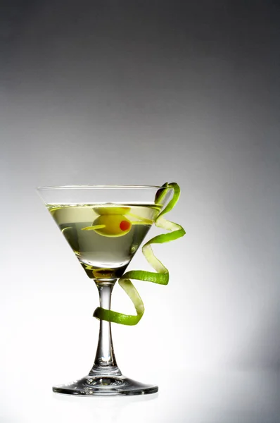 View of martini glass with vermouth and curl of lime rind — Stock Photo, Image