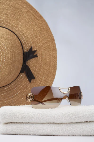 Vista de toalla blanca, gafas de sol y cabaña de paja grande en blanco — Foto de Stock