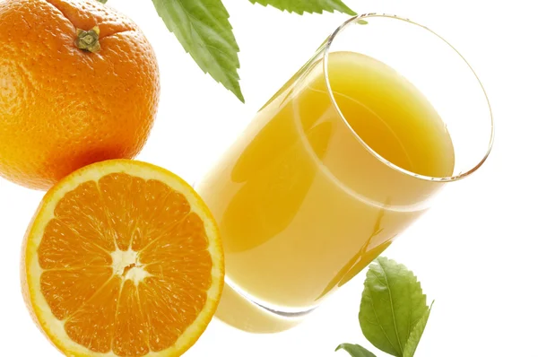 Blick auf schöne frische Orangen und ein Glas Saft daneben — Stockfoto