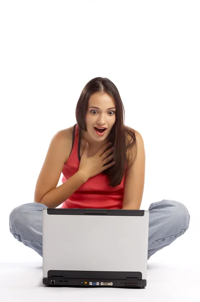 Vista de jovem morena emocional bonito sentado atrás de seu laptop — Fotografia de Stock