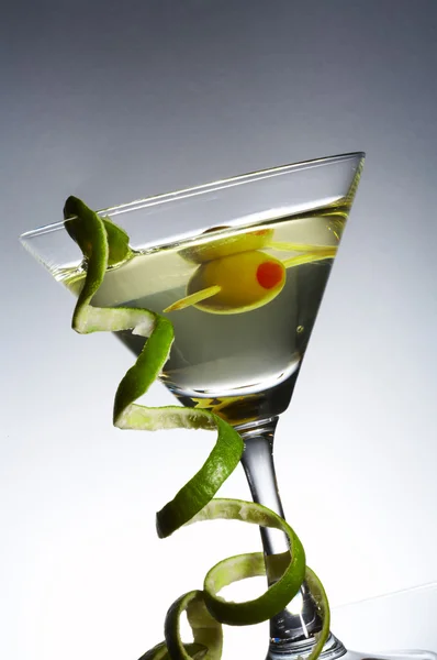 View of martini glass with vermouth and curl of lime rind — Stock Photo, Image