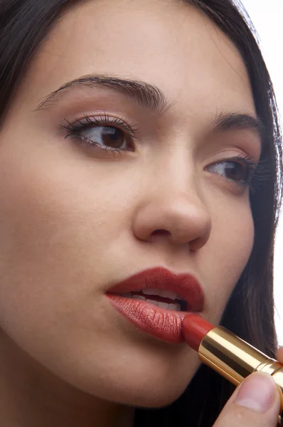 A close-up portrait of a young woman putting on lip liner — Stock Photo, Image