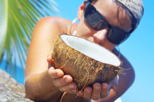 Vista de uma mulher abrindo grande coco em ambiente tropical — Fotografia de Stock