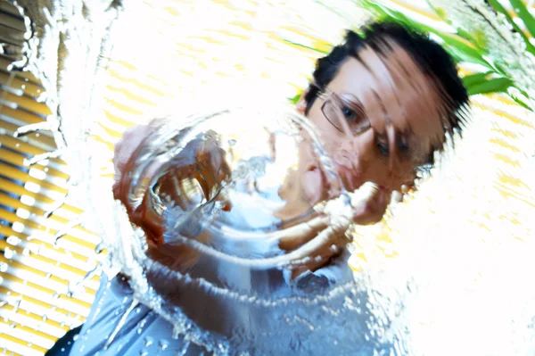 Portrait of woman splashing water un to the camera — Stock Photo, Image