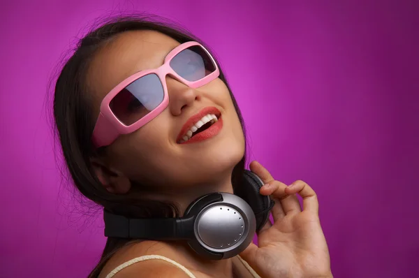 Glamour retrato de joven morena en gafas de sol rosadas escuchando música — Foto de Stock