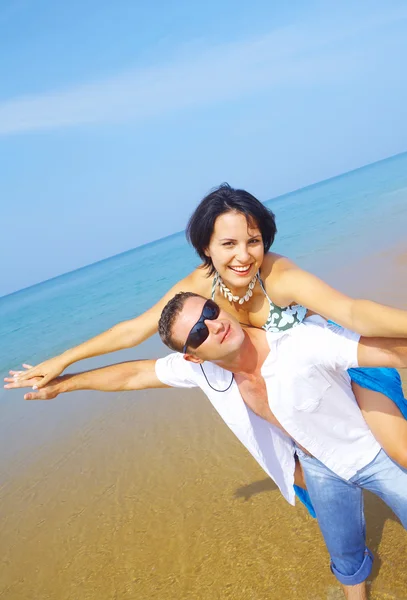 Ett porträtt av attraktiva par att ha kul på stranden — Stockfoto