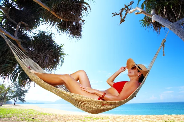 Vista di bella donna sdraiata in amaca in ambiente tropicale — Foto Stock