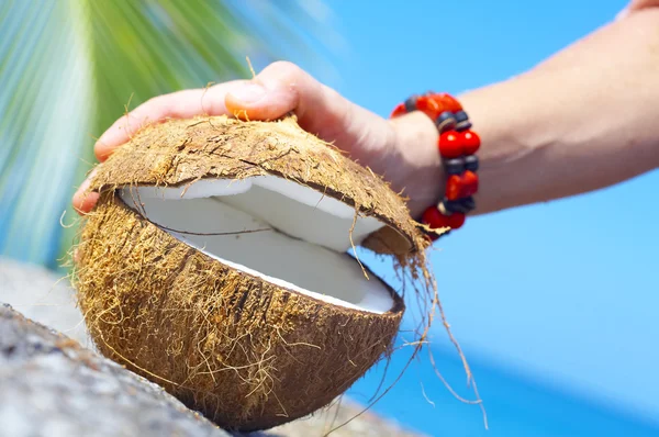 Weergave van een vrouw grote kokosnoot openen in tropische omgeving — Stockfoto