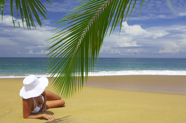 View of nice woman lounging on tropical beach in white panama and bikini — Stock Photo, Image