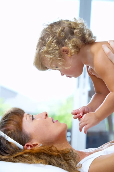 Hög nyckel porträtt av glada mor med baby — Stockfoto