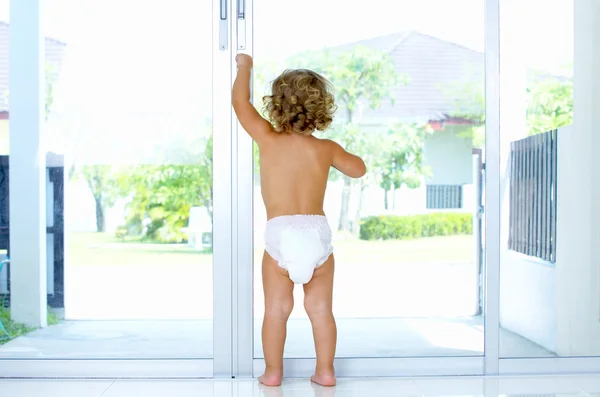 High key portrait of baby trying to get out of house — Stock Photo, Image