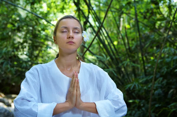 Imagen de una joven practicando yoga en un ambiente tropical —  Fotos de Stock