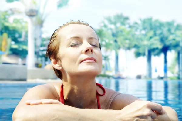 Portrait of nice young woman relaxing in swimming pool — Stock Photo, Image