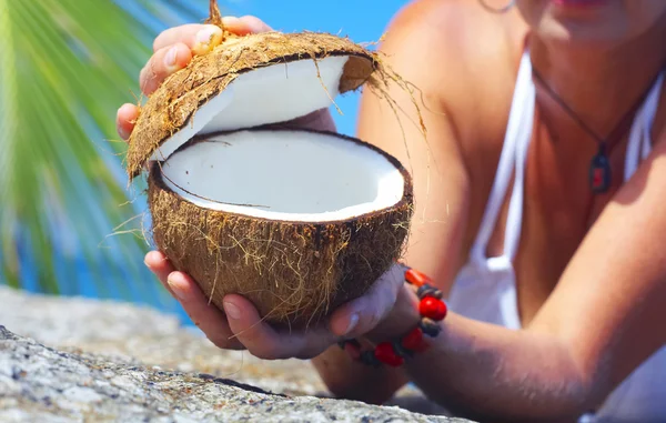 Vista de una mujer abriendo coco grande en ambiente tropical — Foto de Stock