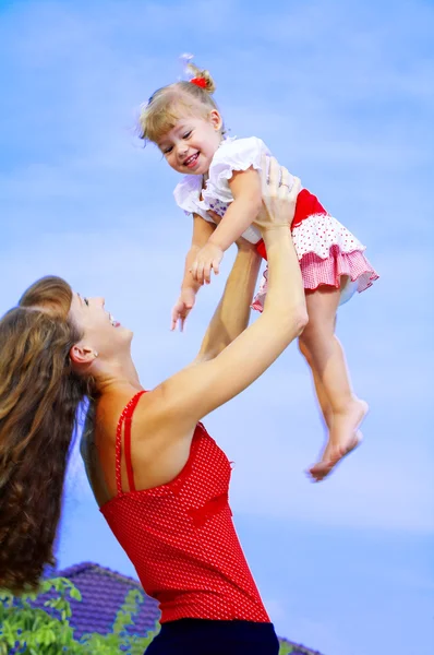 Portrait of young mother with her baby having fun on the beach — Stock Photo, Image