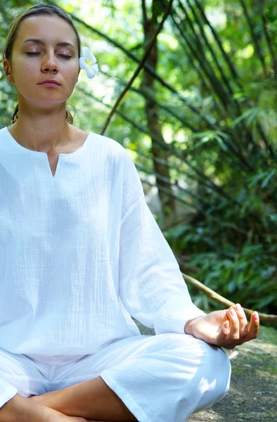 Bild einer jungen Frau, die Yoga in tropischer Umgebung praktiziert — Stockfoto