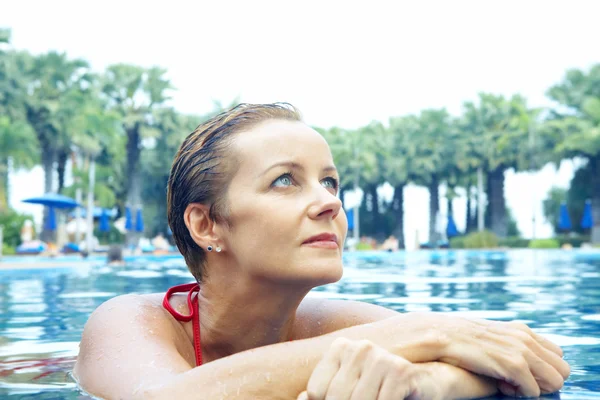 Retrato de bela jovem relaxante na piscina — Fotografia de Stock