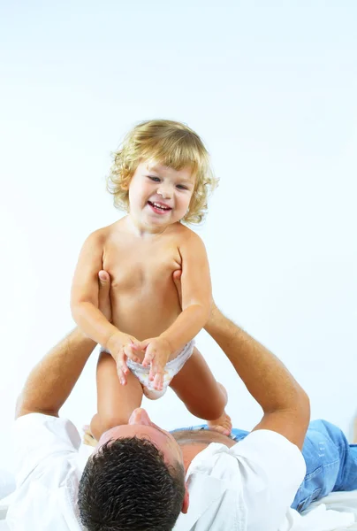 High key portrait of a young man playing with his baby daughter — Stock Photo, Image