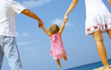 View of young family spending time on the beach