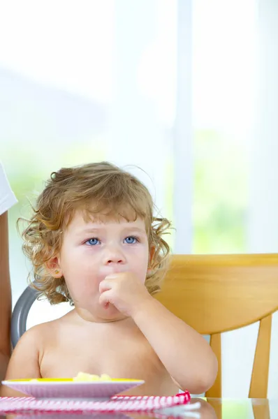 Retrato de bebé rizado agradable durante la hora del almuerzo — Foto de Stock