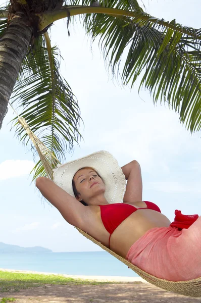 Vista di bella donna sdraiata in amaca in ambiente tropicale — Foto Stock