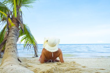 güzel kadının beyaz panama ve bikini tropikal plaj uzanmanız görünümü
