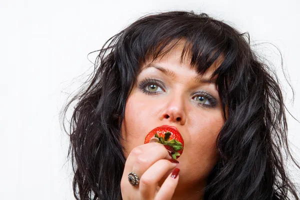 Retrato de morena jovem agradável comendo morango — Fotografia de Stock