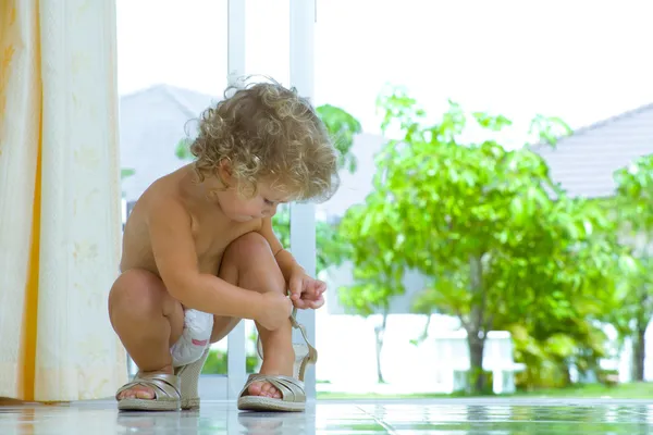 High key portrait of baby trying to put on mamas shoes — Stock Photo, Image