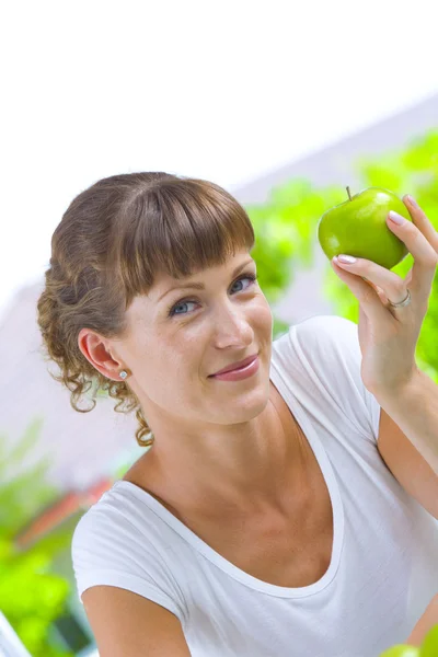 Retrato chave alta de mulher jovem com maçã — Fotografia de Stock
