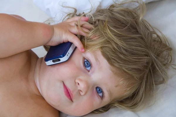 Retrato de chave alta de bebê jovem com telefone celular — Fotografia de Stock