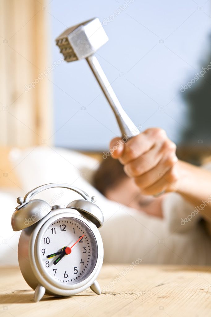 Close up view of big kitchen hammer is ready to crash alarm-clock