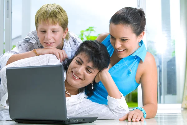 Portrait of happy family getting busy with laptop — Stock Photo, Image