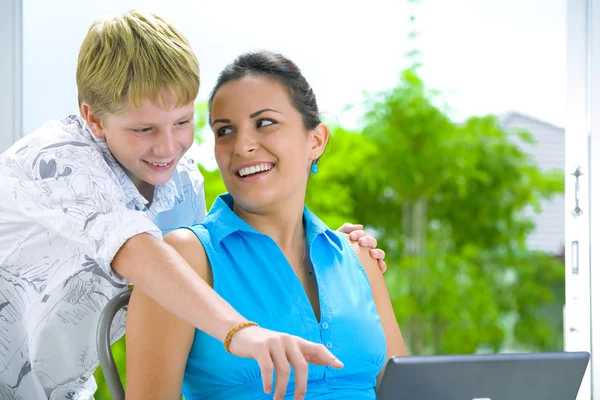 Portrait of young gorgeous woman with her brother etting busy with laptop — Stock Photo, Image