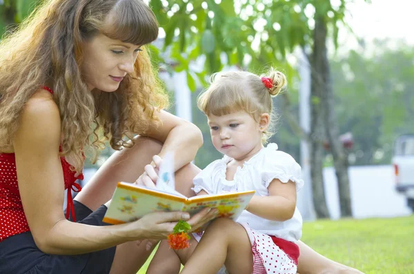 Retrato de jovem mãe e bebê se ocupando com o livro — Fotografia de Stock