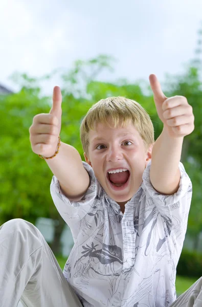 Portret van een jonge jongen zijn duimen opgevend — Stockfoto