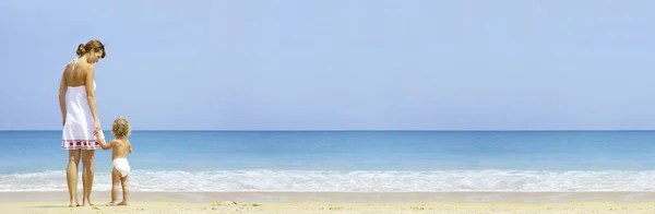 Ritratto di giovane madre con il suo bambino che si diverte sulla spiaggia — Foto Stock