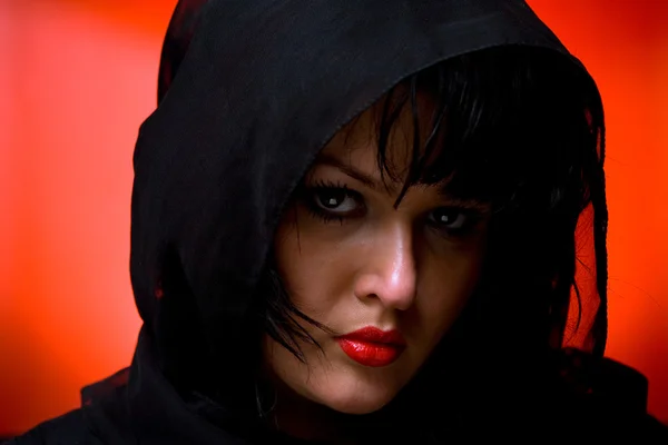 Portret van jonge mooie vrouw in zwarte sluier op rode rug — Stockfoto