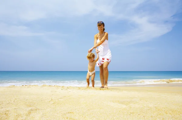 Porträtt av ung mor med sin baby att ha kul på stranden — Stockfoto