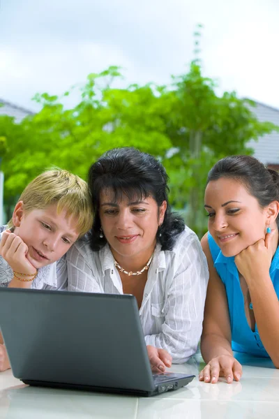 Porträtt av lycklig familj bli upptagen med laptop — Stockfoto