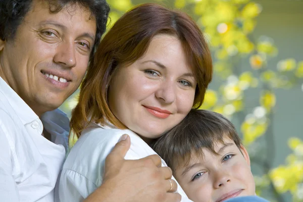 Porträtt av ung glad familj i sommaren miljö — Stockfoto