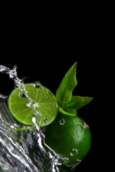 Close up view of fresh limes getting splashed by water — Stock Photo, Image