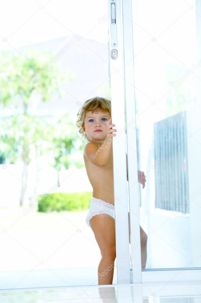 High key portrait of baby trying to get out of house