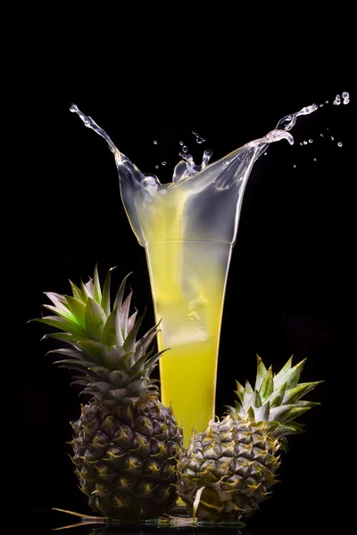 View of fresh pineapple juice splashing out of glass — Stock Photo, Image