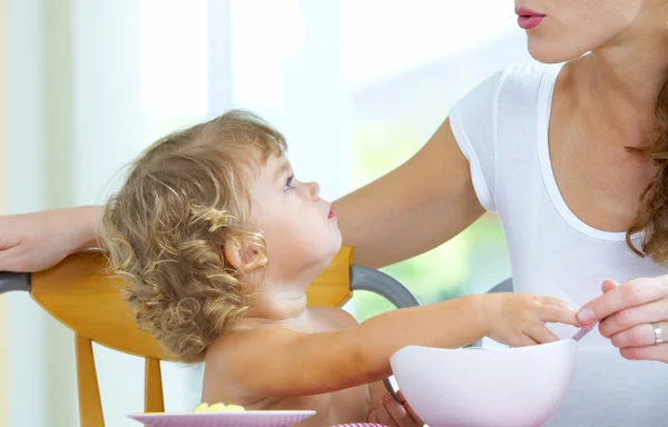 Portrait of young woman feeding her baby daughter — Stock Photo, Image