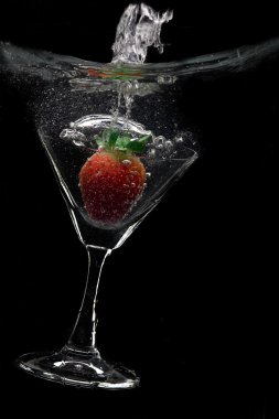 siyah arka plan üzerine çilek ile martini cam görünümü