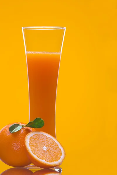 Vista de la pieza de naranja y el vaso de jugo en la espalda —  Fotos de Stock