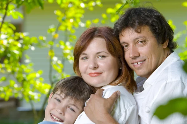 Porträtt av ung glad familj i sommaren miljö — Stockfoto